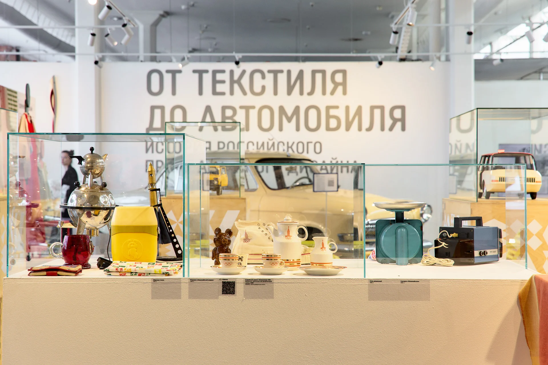 Бытовые предметы, олимпийский фарфор и автомобильные макеты в витринах.